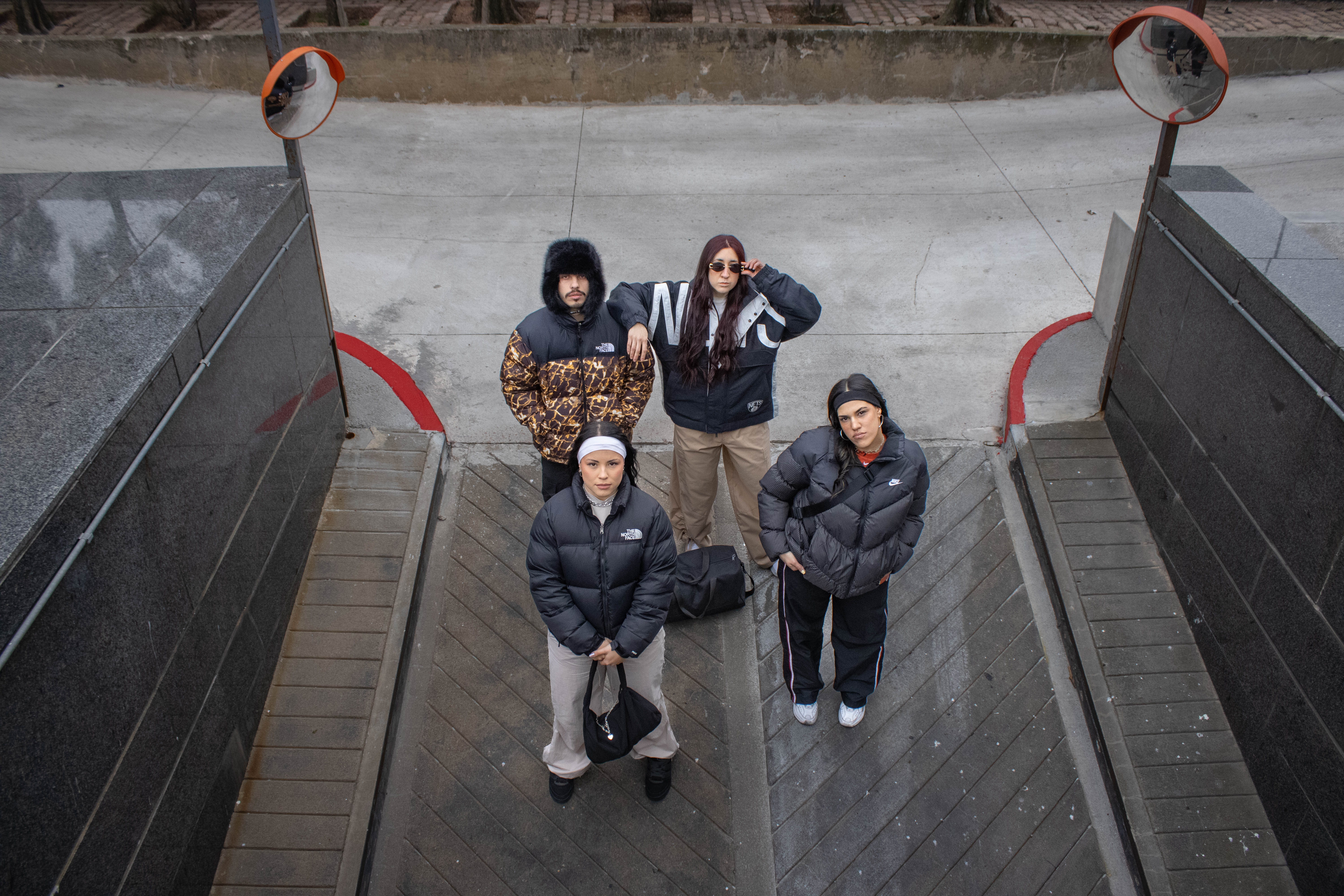 Cuatro amigos con camperas puffer vistos desde arriba en una rampa urbana — klok curated secondhand